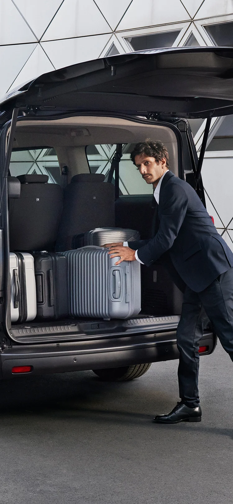Arrière de la Citroën ë-SpaceTourer avec le coffre ouvert, montrant plusieurs valises en train de se charger